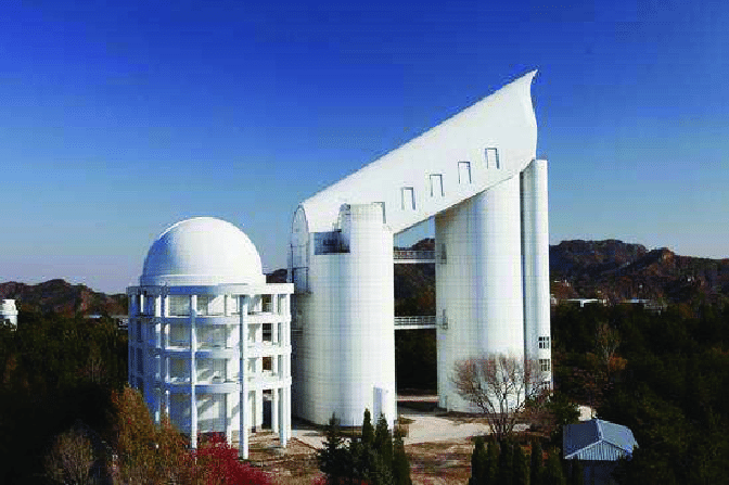 A long white tube-shaped building on top of a mountain